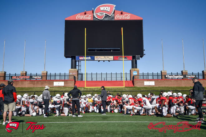Head Coach Tyson Helton and staff gather around players during a 2021 spring practice. (Photo: @WKUFootball Twitter)