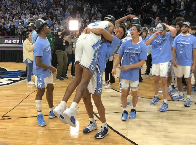 Armando Bacot (5) is hoisted into the air by teammate Justin McKoy after UNC won Sunday night.