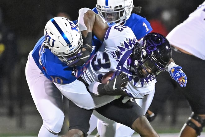 Marcus Harris (50) tackles TCU running back Kendre Miller last fall.