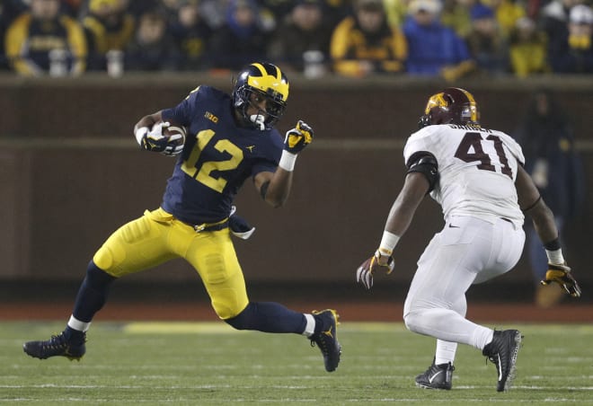 Michigan sophomore tailback Chris Evans prepares to dismiss another Golden Gopher.
