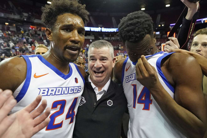 Boise State's Abu Kigab (24) and Emmanuel Akot (14) celebrates with coach Leon Rice following their victory over San Diego State in an NCAA college basketball game in the finals of Mountain West Conference men's tournament Saturday, March 12, 2022, in Las Vegas.