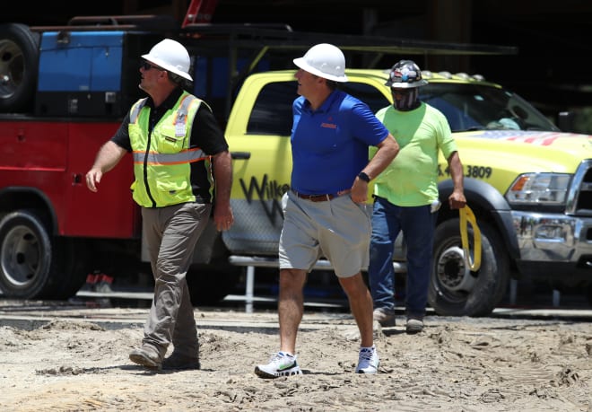 Dan Mullen watches as the final beam is placed atop the James W. “Bill” Heavener Football Training Center / Tim Casey 