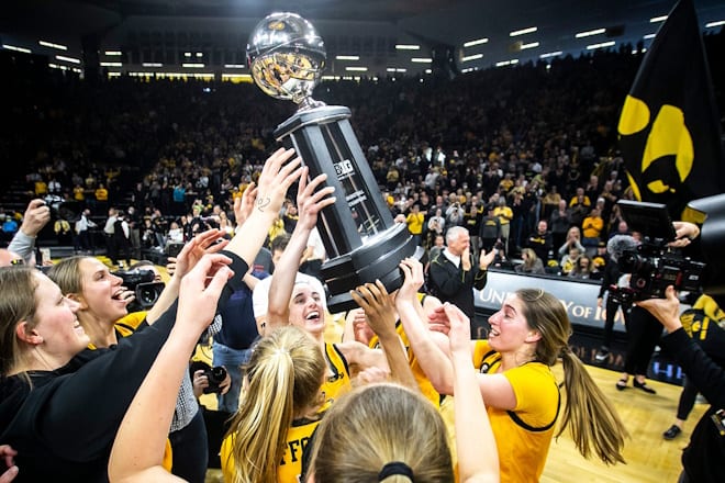 Iowa guards Caitlin Clark and Kate Martin celebrate with their Big Ten regular season championship trophy after a NCAA Big Ten Conference women's basketball game against Michigan, Sunday, Feb. 27, 2022, at Carver-Hawkeye Arena in Iowa City, Iowa.