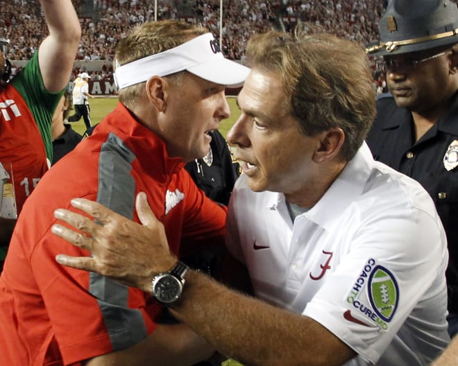 Ole Miss coach Hugh Freeze and Alabama coach Nick Saban meet at midfield following the Rebels' 43-37 win in Tuscaloosa on Sept. 19, 2015. 