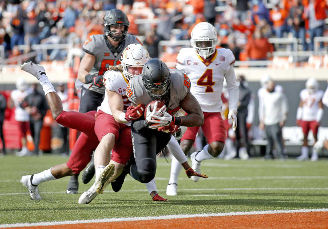 Oklahoma State's Jelani Woods scores a touchdown as Iowa State's Mike Rose defends.