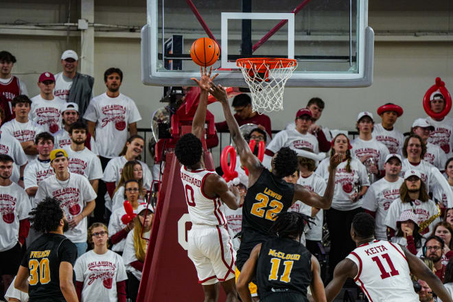 Le'Tre Darthard (0) rolls in a layup as an enraptured group of students looks on