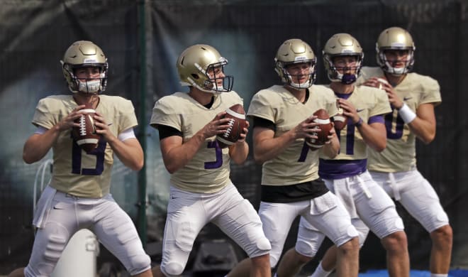 Washington quarterbacks Jake Haener (13), Jake Browning (3), Colson Yankoff (7), Jacob Simon (11) and Jacob Eason, right, line-up to throw during drills at NCAA college football practice Friday, Aug. 10, 2018, in Seattle. (AP Photo/Elaine Thompson)