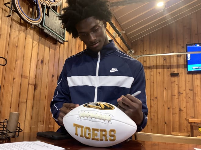 Rakestraw signs a football that will be put on sale on hornsdownshop.com.