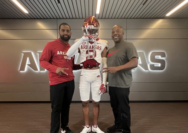 2025 cornerback Caleb Chester (middle) and Arkansas secondary coach Deron Wilson (left). @CalebChester_