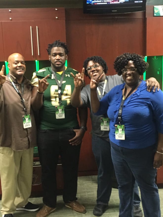 Harris' family poses in the locker room during his official visit