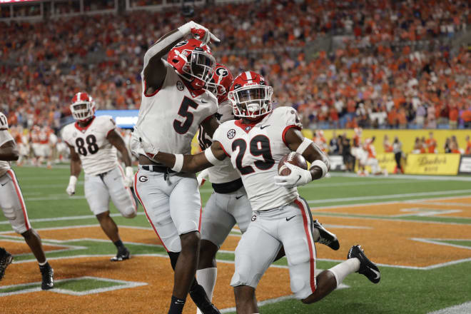 Christopher Smith celebrates with Kelee Ringo and others following his pick-six against Clemson. (Andrew David Tucker/UGA Sports Communications)