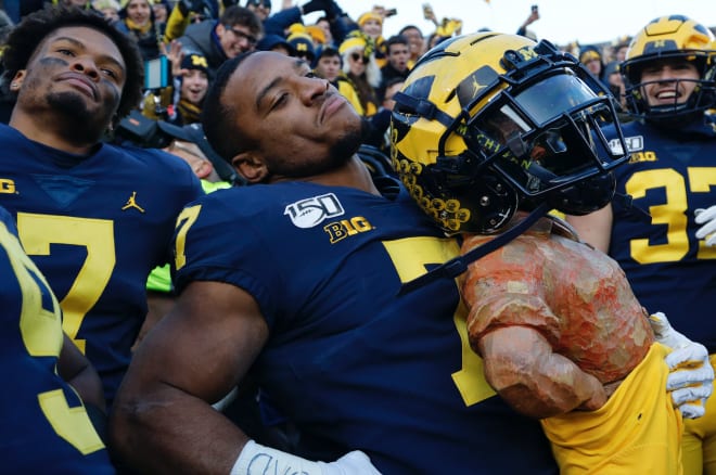 Michigan players celebrate with the Paul Bunyan trophy after hammering Michigan State.