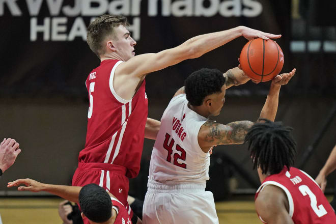 Wisconsin's Tyler Wahl, left,  block Rutgers' Jacob Young (42) during the first half.