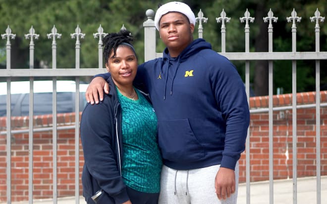 Five-star defensive tackle Walter Nolen holds a Michigan Wolverines football recruiting, Jim Harbaugh.