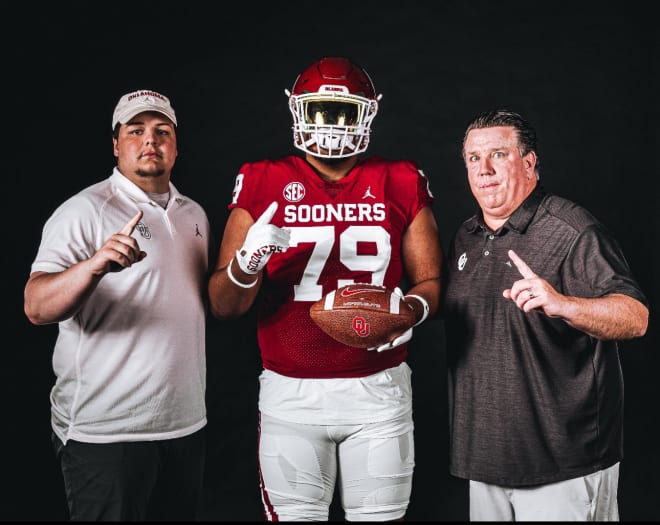 Afalava poses with OL assistant Ben Tawwater and OL coach Bill Bedenbaugh