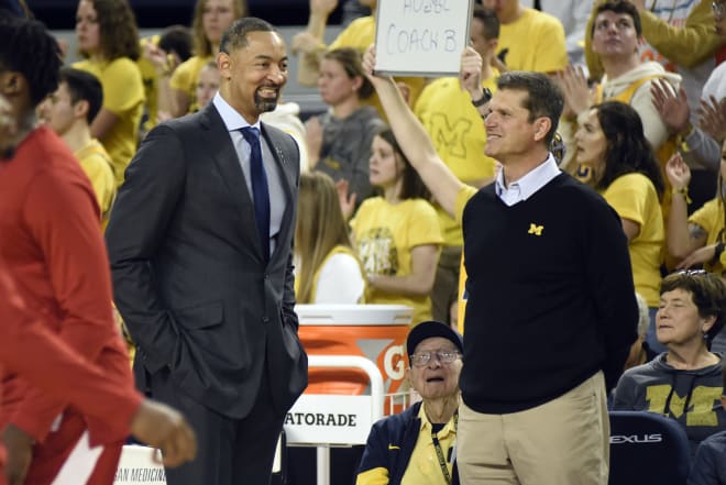 Michigan men Juwan Howard (the tall one) and Jim Harbaugh (the one wearing khakis as part of a uniform) discuss myocarditis back in March. Thank God they solved it!