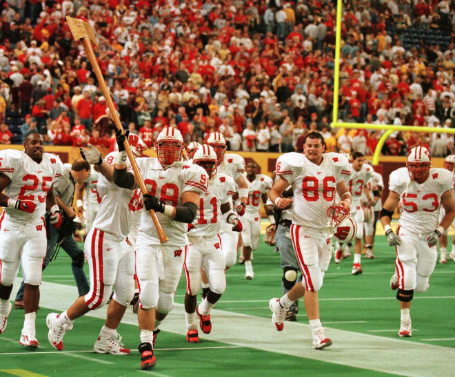 Wisconsin's Mark Neuser (98) carries Paul Bunyan's Axe as he and his Badger teammates circle the field after beating Minnesota in overtime 20-17 in Minneapolis.