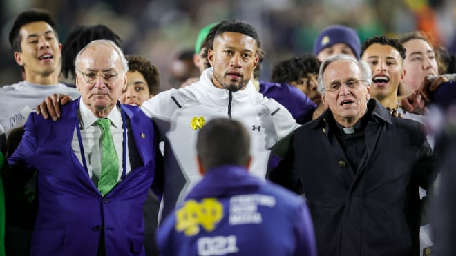 From left Notre Dame athletic director Jack Swarbrick, head coach Marcus Freeman and president Rev. John Jenkins sign the Alma Mater following ND's 45-7 win over Wake Forest on Saturday.   