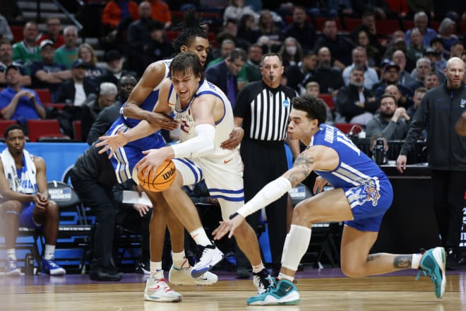 Boise State forward Tyson Degenhart, second from left, is wrapped up by Memphis guard Earl Timberlake, left, as Memphis guard Lester Quinones, right, reaches in, during the first half of a first round NCAA college basketball tournament game, Thursday, March 17, 2022, in Portland, Ore.