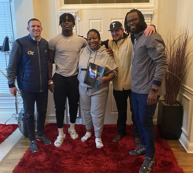 Odinjor poses with his mom and a trio of Tech coaches during an in-home visit