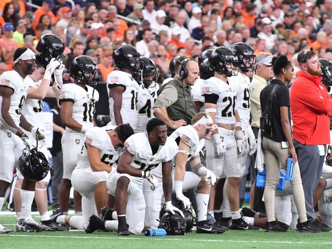 The Army Football Brotherhood looks on as Miller is being attended to