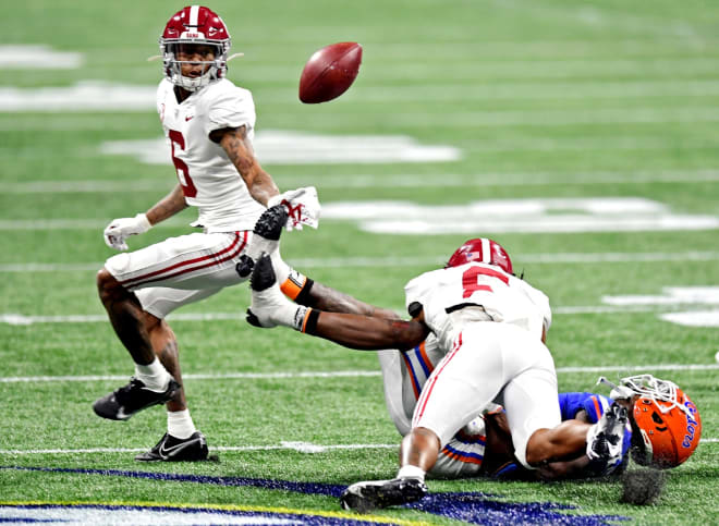 Alabama Crimson Tide wide receiver John Metchie III (8) forces Florida Gators defensive back Trey Dean III (0) to fumble during the first quarter in the SEC Championship at Mercedes-Benz Stadium. Photo | Imagn.