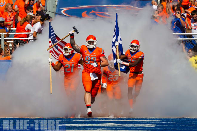 Boise State's Scott Matlock (99) leads the Broncos onto the field carrying the 'Dan Paul Hammer' prior to their game with rival Nevada. 