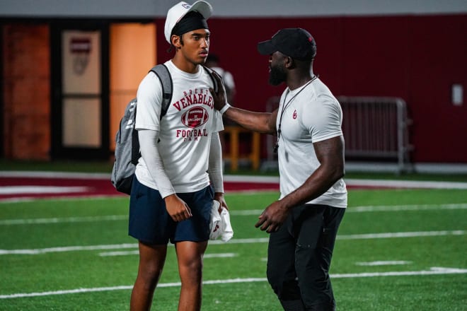 Oklahoma cornerbacks coach Jay Valai chats with Hawkins after a camp session