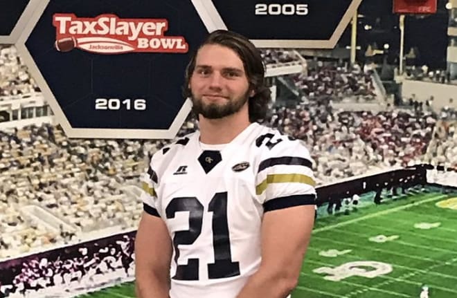 Johns poses in a GT jersey during his visit Thursday to the Flats