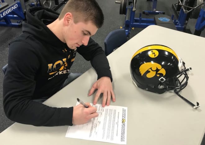 Jaden Snyder signs paperwork to walk on at the University of Iowa.