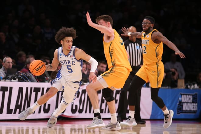 Duke's Tyrese Proctor turns the corner against Vermont's TJ Hurley, center, and Shamir Bogues, right, on Friday night. 