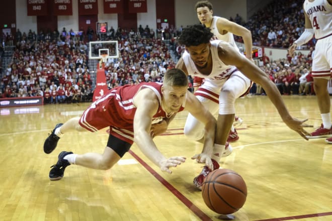 Wisconsin guard Brevin Pritzl, left, dives for a loose ball in front of Indiana forward Jerome Hunter in the second half of an NCAA college basketball game in Bloomington, Ind., Saturday, March 7, 2020. Wisconsin won 60-56.