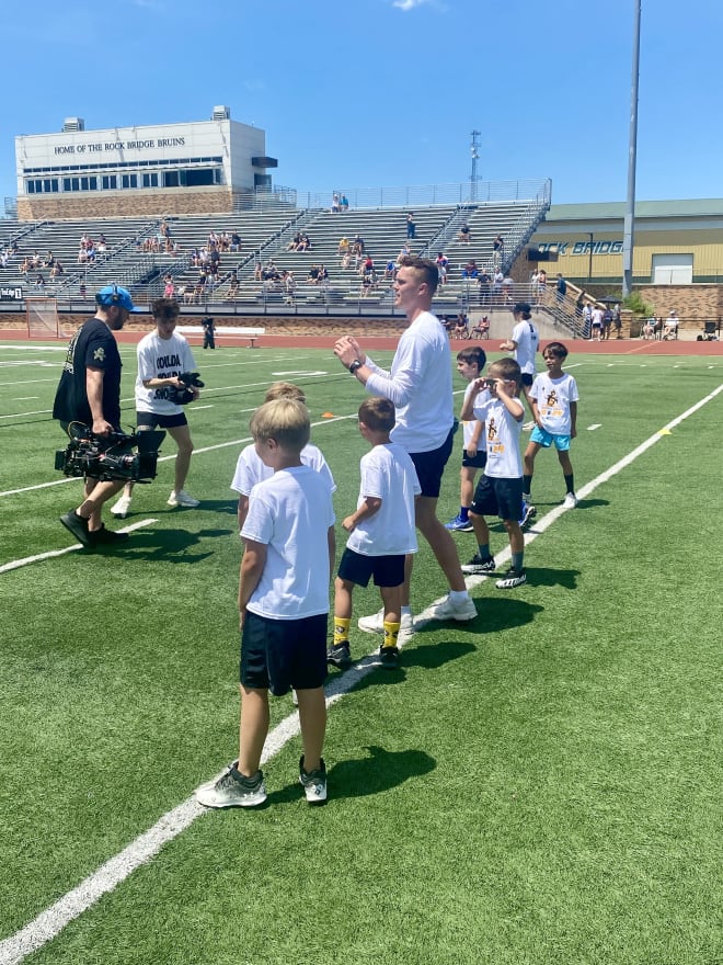 Brady Cook awaits the football as he looks to throw the ball with some of his campers.