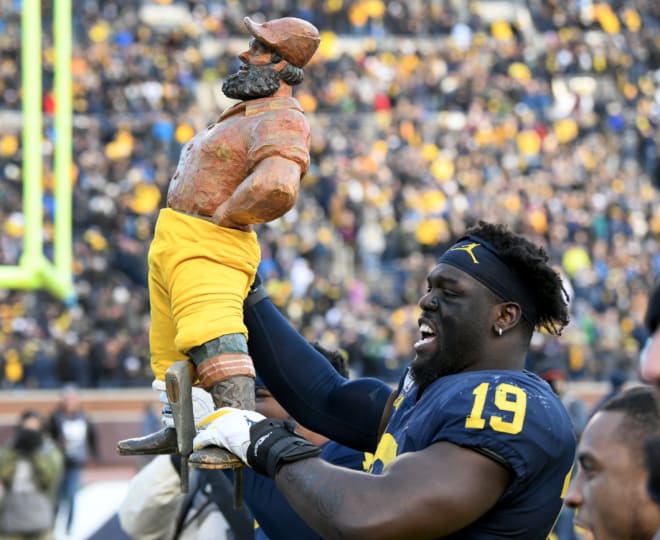 Michigan Wolverines football defensive end Kwity Paye holds the Paul Bunyan Trophy