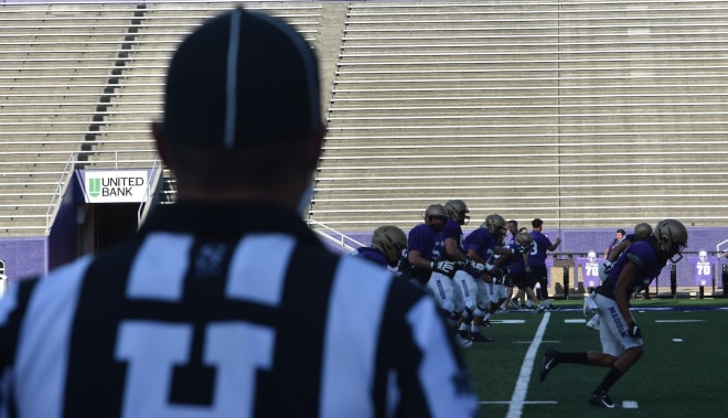 James Madison's offense runs a play prior to the start of the Dukes' scrimmage as an official looks on. 