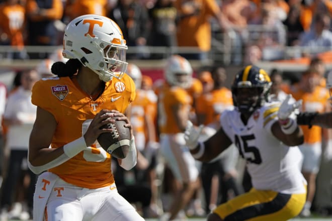 Tennessee quarterback Nico Iamaleava, left, looks for a receiver as Iowa defensive lineman Deontae Craig (45) rushes during the first half of the Citrus Bowl NCAA college football game, Monday, Jan. 1, 2024, in Orlando, Fla. (AP Photo/John Raoux)