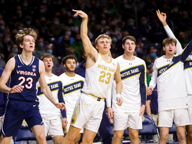 Notre Dame's Dane Goodwin, center, reacts after hitting a 3-pointer next to Virginia's Kody Stattmann, left, during a 69-65 Irish victory