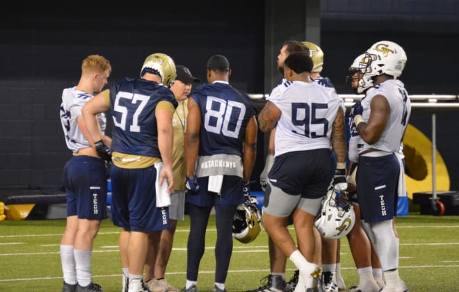 Coach Collins meets with his team leaders during a break in practice on Tuesday
